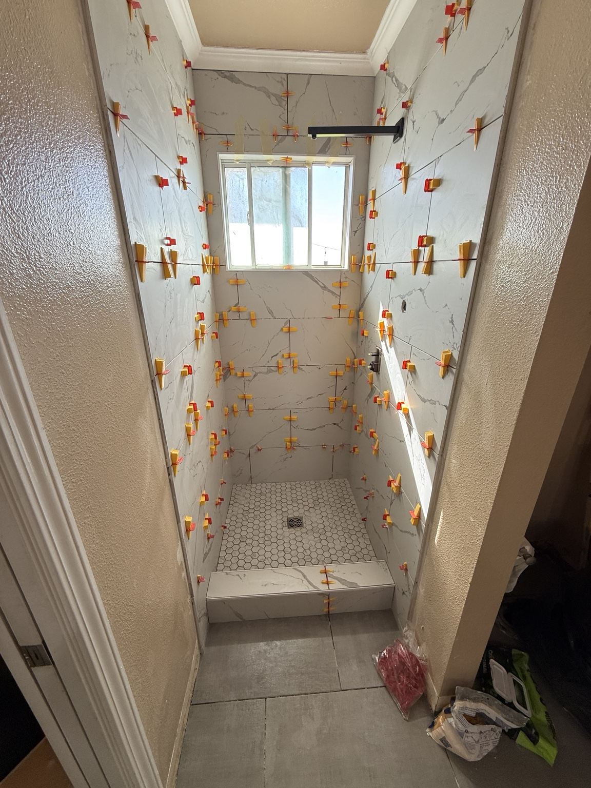 Tile installation in progress with leveling clips