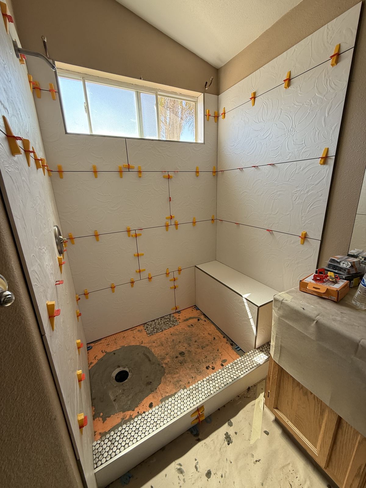Tile installation in progress with leveling clips